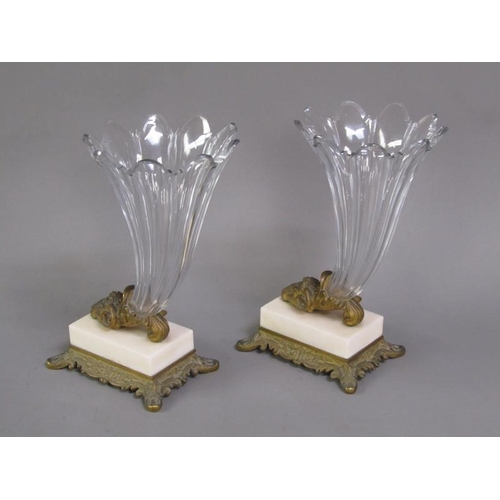 77 - A pair of early 19c rams head cornucopia, the cut clear glass vases supported by gilt metal rams hea... 