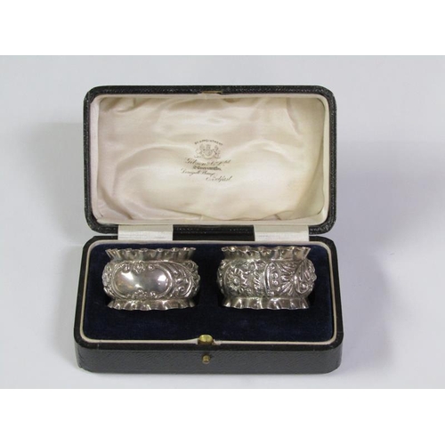 166 - A pair of boxed silver napkin rings, chased and embossed, Birmingham 1897, 1.2oz t.