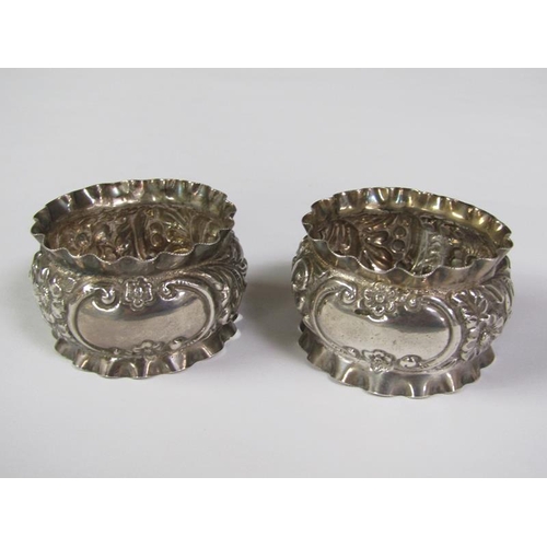 166 - A pair of boxed silver napkin rings, chased and embossed, Birmingham 1897, 1.2oz t.