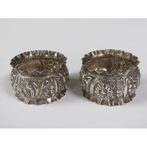 166 - A pair of boxed silver napkin rings, chased and embossed, Birmingham 1897, 1.2oz t.