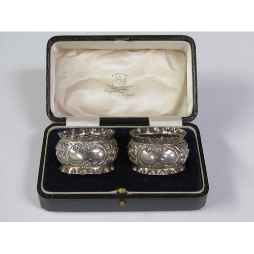 166 - A pair of boxed silver napkin rings, chased and embossed, Birmingham 1897, 1.2oz t.