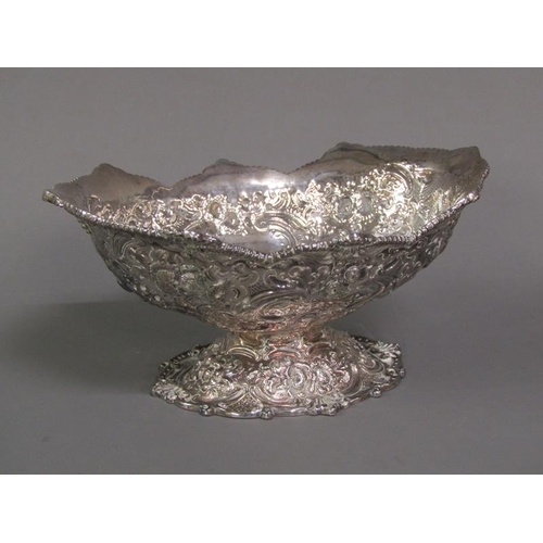 191 - A pair of late Victorian boat shapes bowls on stands with shaped upper rims, embossed and chased thr... 