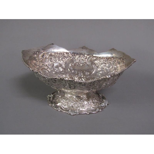 191 - A pair of late Victorian boat shapes bowls on stands with shaped upper rims, embossed and chased thr... 