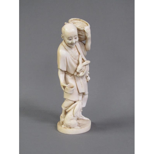 82 - A Japanese Meiji period ivory figure group of a rabbit keeper, base with incised signature, 17cm h.