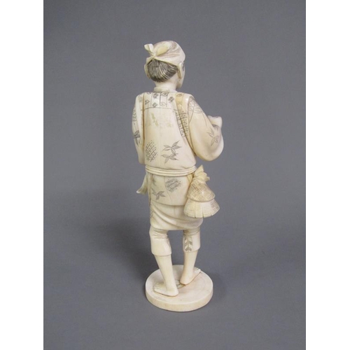 83 - A Japanese Meiji period carved ivory figure of a gentleman carrying two fish, base with incised sign... 