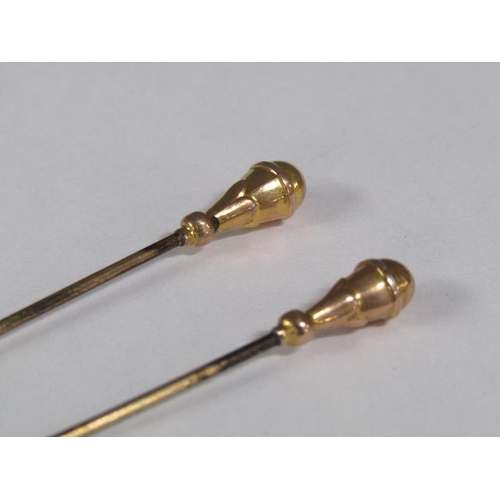 111 - Four Edwardian hat pins each with gold terminals, two being a pair.