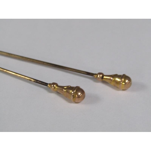 111 - Four Edwardian hat pins each with gold terminals, two being a pair.