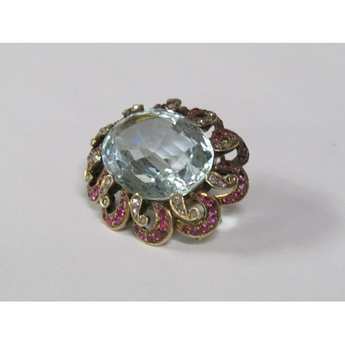 120 - A late 19c/early 20c aquamarine brooch, the central stone surrounded by a border of rubies and diamo... 