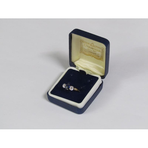 124 - An 18ct gold ring set with a central cut sapphire flanked by two diamonds.