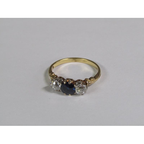 124 - An 18ct gold ring set with a central cut sapphire flanked by two diamonds.