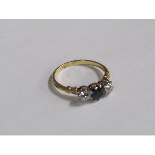 124 - An 18ct gold ring set with a central cut sapphire flanked by two diamonds.