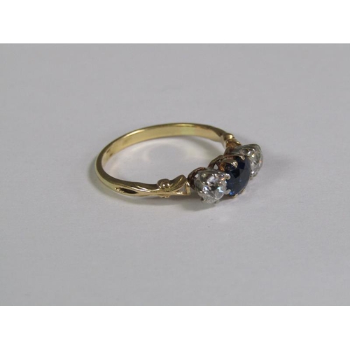 124 - An 18ct gold ring set with a central cut sapphire flanked by two diamonds.