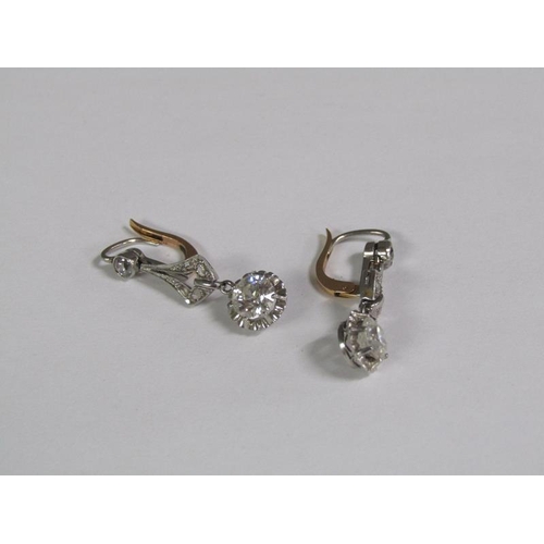 125 - A pair of gold platinum diamond earrings with solitaire drops, each approx. 0.5ct.