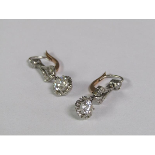 125 - A pair of gold platinum diamond earrings with solitaire drops, each approx. 0.5ct.