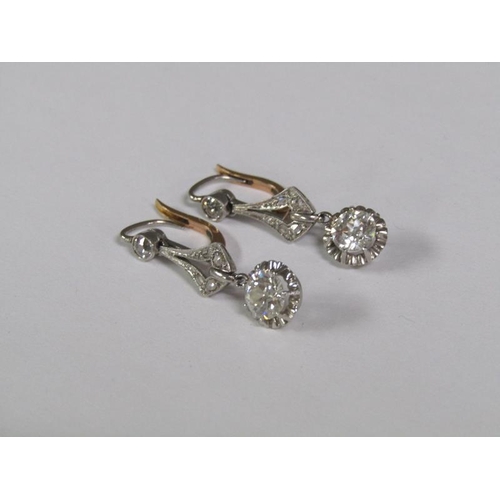 125 - A pair of gold platinum diamond earrings with solitaire drops, each approx. 0.5ct.