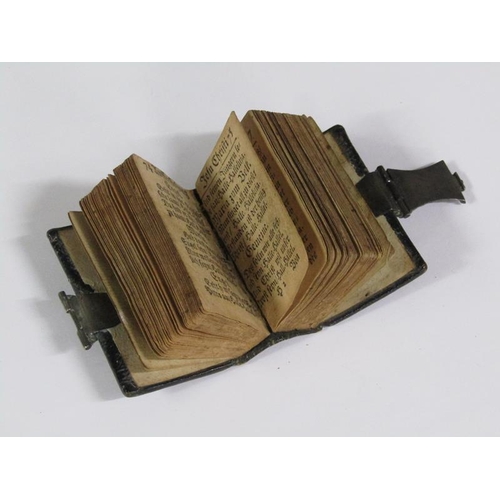 64 - A late 17c German miniature prayer book with embossed leather spine and boards, together with a whit... 