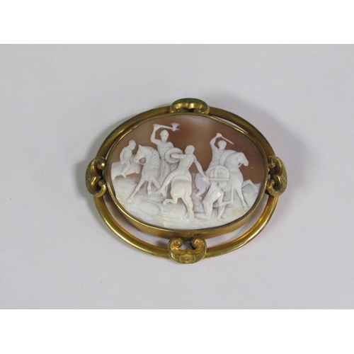 134 - A late 19c/early 20c shell cameo brooch of oval form depicting a battle scene on horse back, in a gi... 