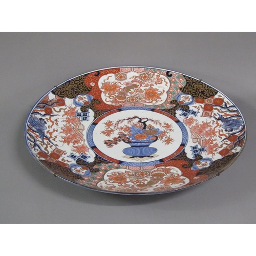 222 - A large Imari charger painted with a central vase of flowers encircled by panels of exotic beasts an... 