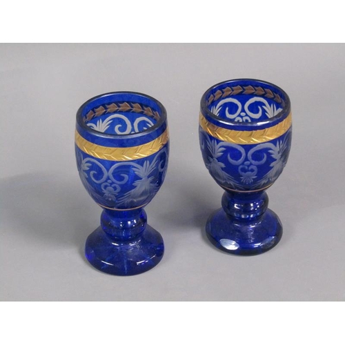 215 - A pair of late 19c/early 20c blue flashed goblet glasses with gilt banding and rim, each 15cm h.