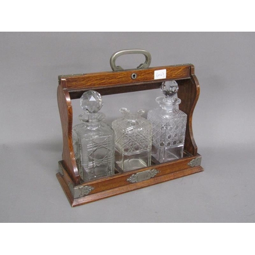 1217 - EARLY 20C EDWARDIAN OAK THREE BOTTLE TANTALUS, TWO BOTTLES A/F, 36CM W AT BASE