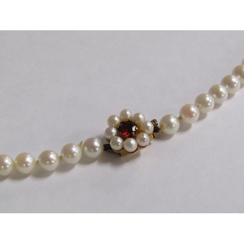 100 - A string of cultured pearls, 55cm l, with gold stone set clasp.