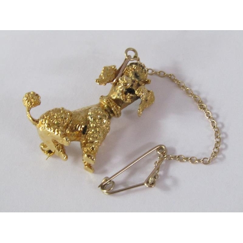 109 - A 9ct gold poodle brooch with ruby eyes and a safety chain, 5.6g.