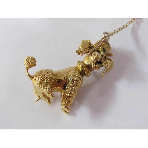109 - A 9ct gold poodle brooch with ruby eyes and a safety chain, 5.6g.