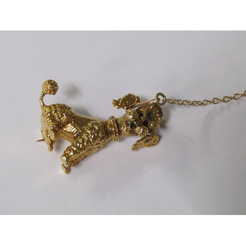 109 - A 9ct gold poodle brooch with ruby eyes and a safety chain, 5.6g.