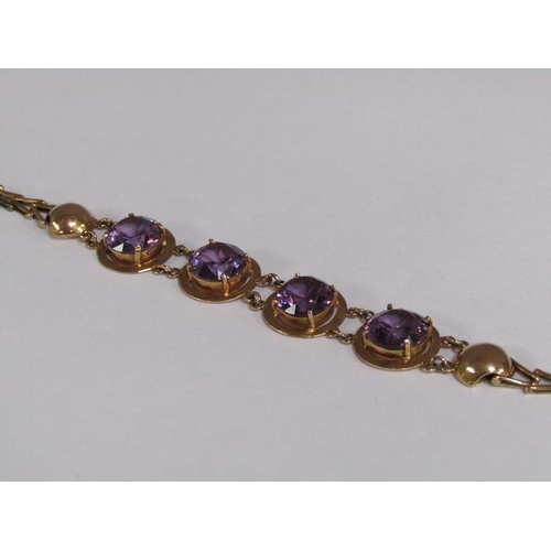 120 - An Egyptian gold bracelet set with four cut amethysts, total 18.4g, 18.5cm l.
