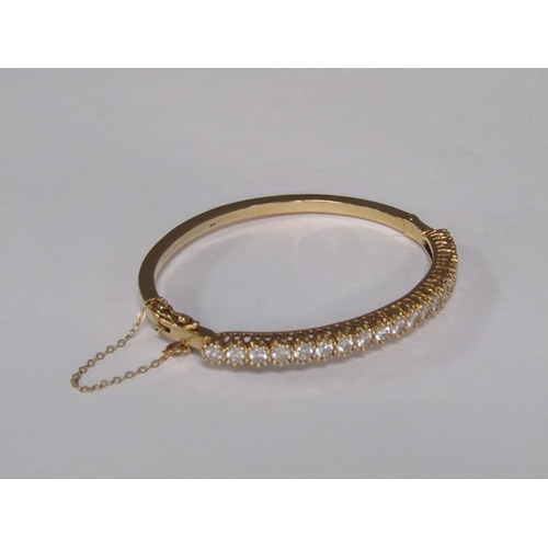 123 - A gold bracelet set with a continuous band of twenty brilliant cut diamonds, total 20g.