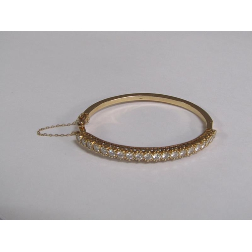 123 - A gold bracelet set with a continuous band of twenty brilliant cut diamonds, total 20g.