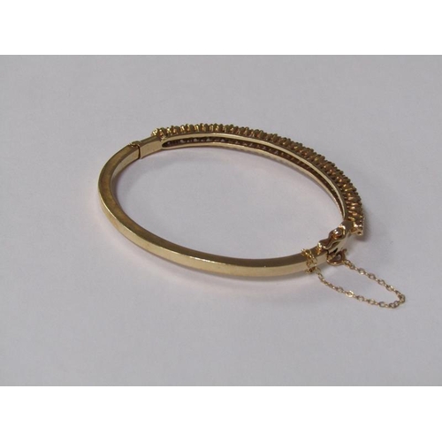 123 - A gold bracelet set with a continuous band of twenty brilliant cut diamonds, total 20g.