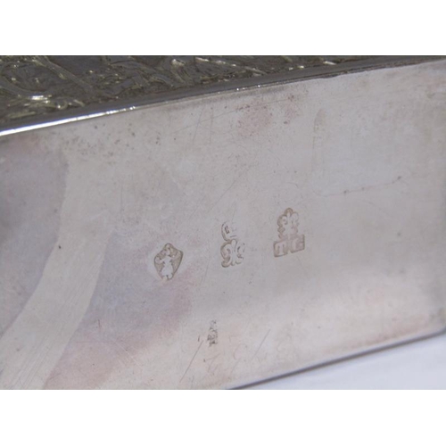 161 - A late Victorian snuff box, embossed with village scenes and the lid with the scene of two soldiers ... 