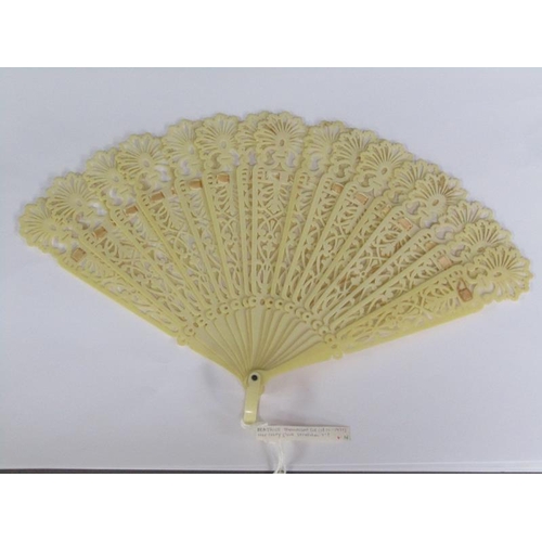 67 - A Victorian ivory fan with silk ribbon with pierced sticks, 39cm w.