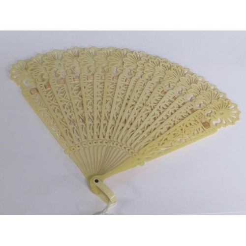 67 - A Victorian ivory fan with silk ribbon with pierced sticks, 39cm w.