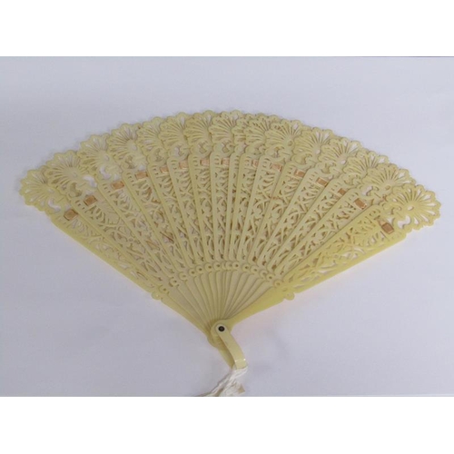 67 - A Victorian ivory fan with silk ribbon with pierced sticks, 39cm w.