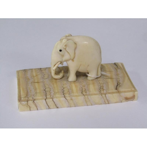 72 - A 19c carved ivory elephant supported on a carved mammoth tooth, 8cm x 4cm.