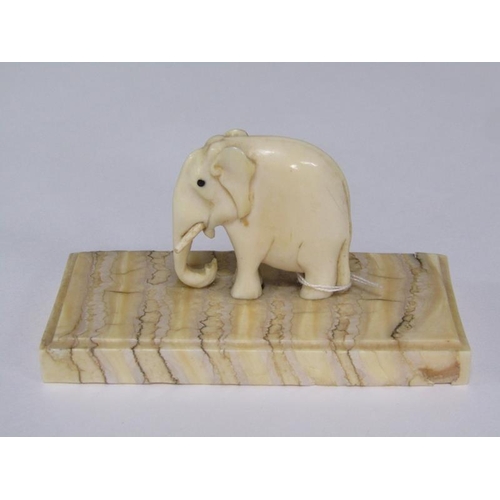 72 - A 19c carved ivory elephant supported on a carved mammoth tooth, 8cm x 4cm.