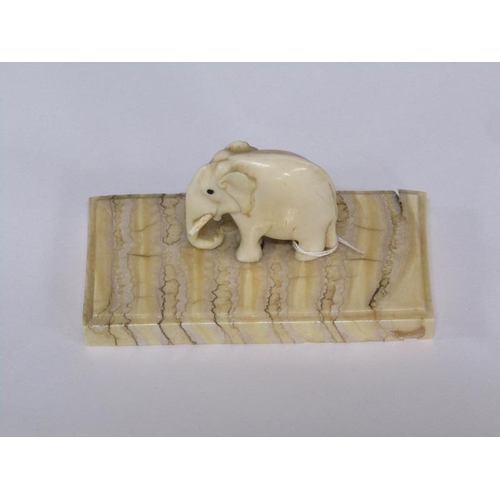 72 - A 19c carved ivory elephant supported on a carved mammoth tooth, 8cm x 4cm.