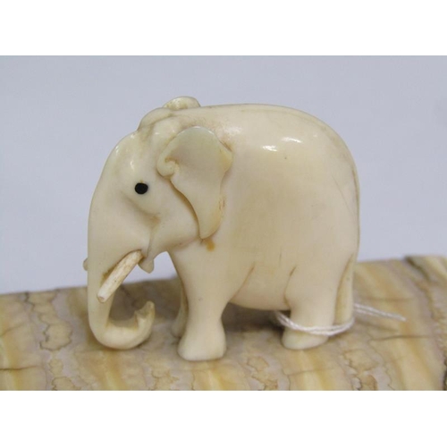72 - A 19c carved ivory elephant supported on a carved mammoth tooth, 8cm x 4cm.