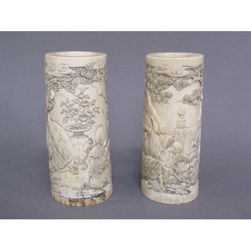 73 - A pair of Japanese ivory vases carved with a scene of Shoulao seated and with children and attendant... 