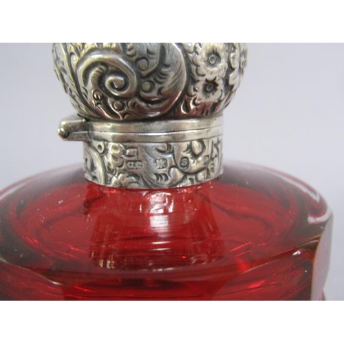 79 - A late Victorian ruby glass scent bottle, facet cut and with an embossed silver hinged dome top and ... 