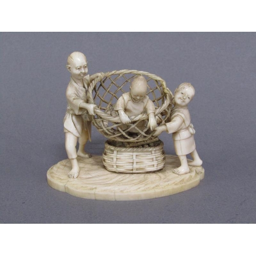82 - A Japanese Meiji period ivory figure group of a lady and gentleman holding aloft a basket containing... 