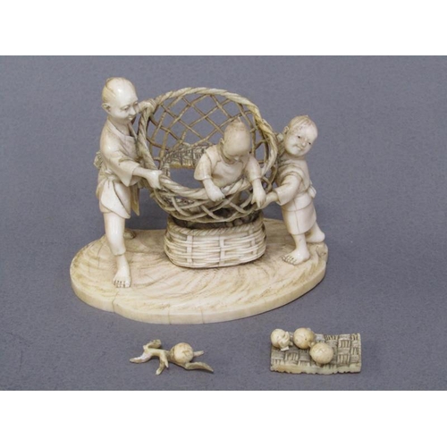 82 - A Japanese Meiji period ivory figure group of a lady and gentleman holding aloft a basket containing... 