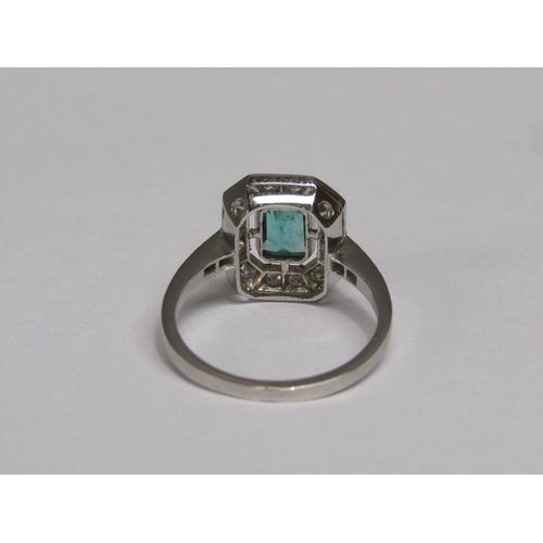140 - A platinum emerald (0.9ct) and diamond (total 0.5ct) cluster ring, size N/O.