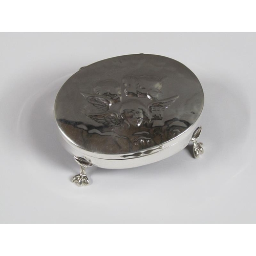 1436 - SILVER RING BOX OF OVAL FORM WITH ANGEL FACE COVER SUPPORTED ON FOUR LEGS