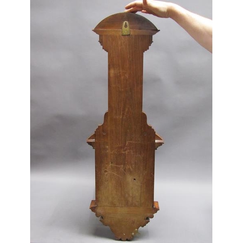 36 - An early 20c aneroid wall barometer, with 20cm diam. silvered dial set into a large heavily carved w... 