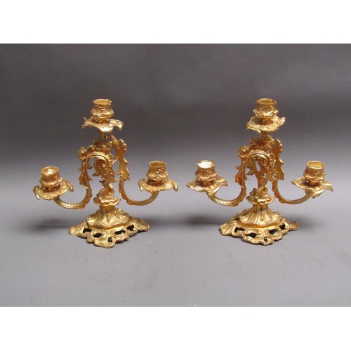 42 - A pair of 19c gilt metal two branch rococo style candelabrum with impressed marks 'EM 23', 24cm w, 2... 