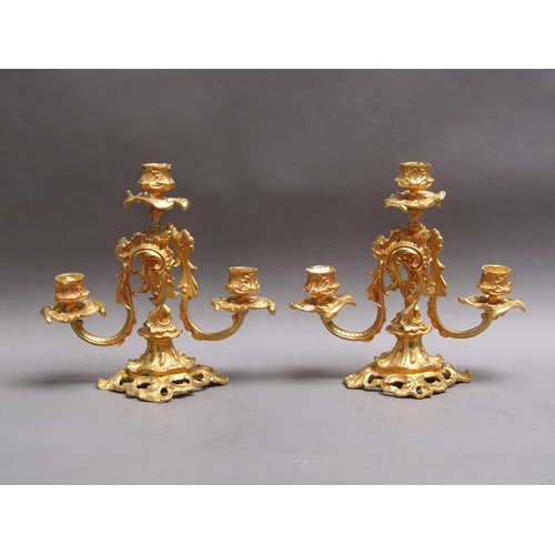 42 - A pair of 19c gilt metal two branch rococo style candelabrum with impressed marks 'EM 23', 24cm w, 2... 