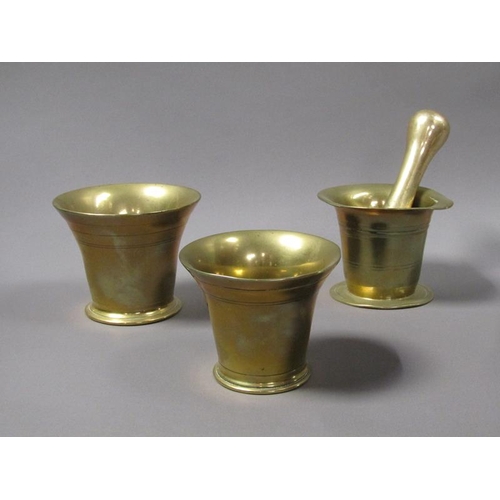 54 - A late 18c/early 19c bronze mortars and a pestle, the mortars, 12.5cm, 13cm & 14cm diam mouths, and ... 